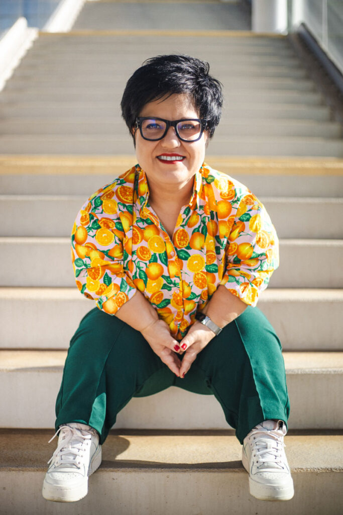 Justyna Cuże siedzi na schodach, uśmiechając się do aparatu.