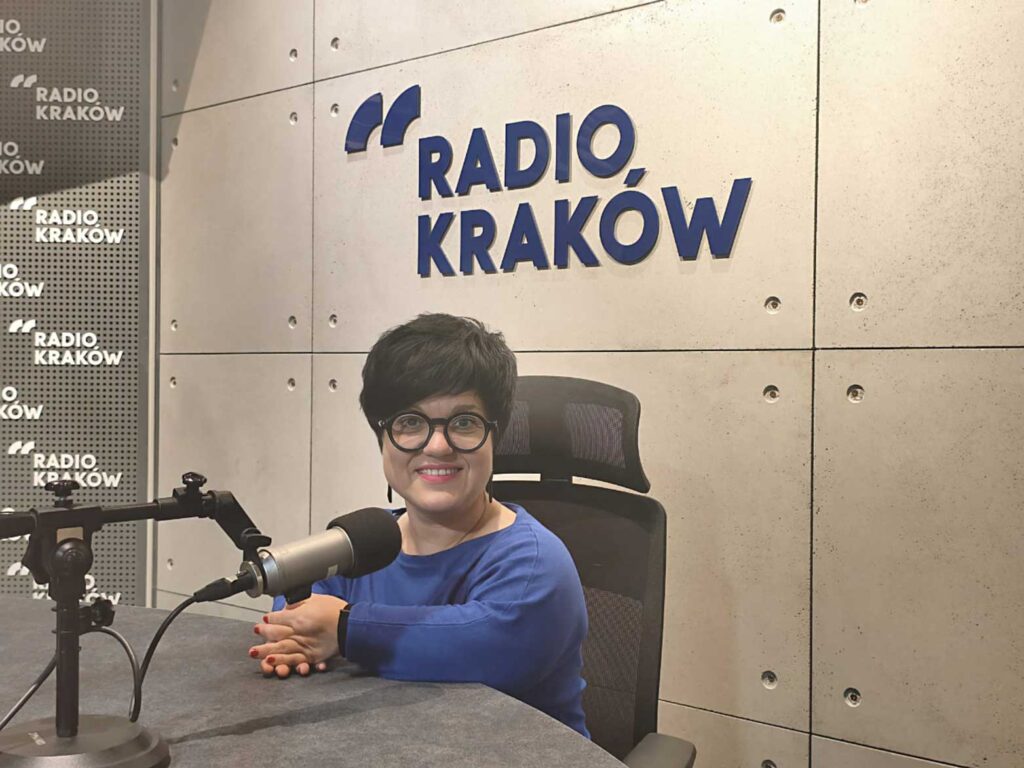 Justyna Cuże siedzi w studiu Radia Kraków przed mikrofonem.